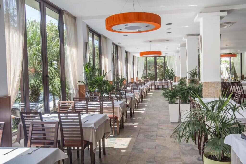 Hotel restaurant with large windows and set tables